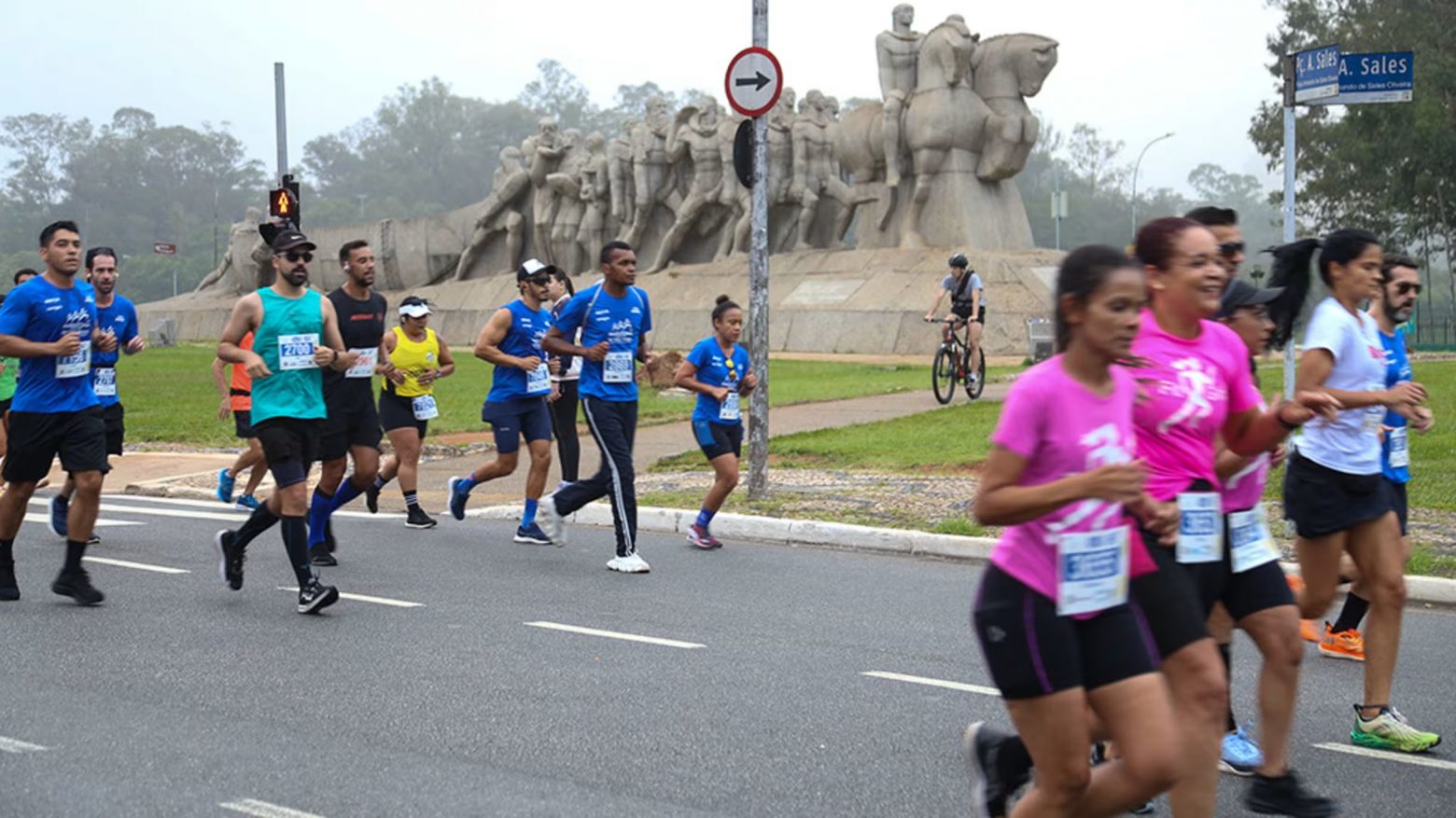 Pessoas correndo na Maratona de São Paulo. Monumento no fundo.
