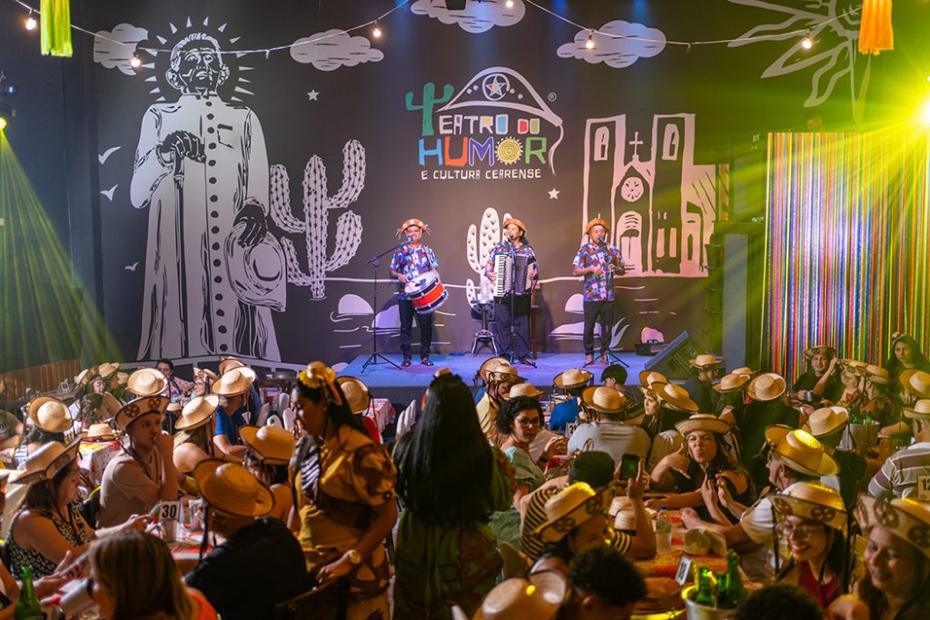 Show de Humor - Fortaleza, pessoas com chapéu de cangaceiro, banda de forró no palco