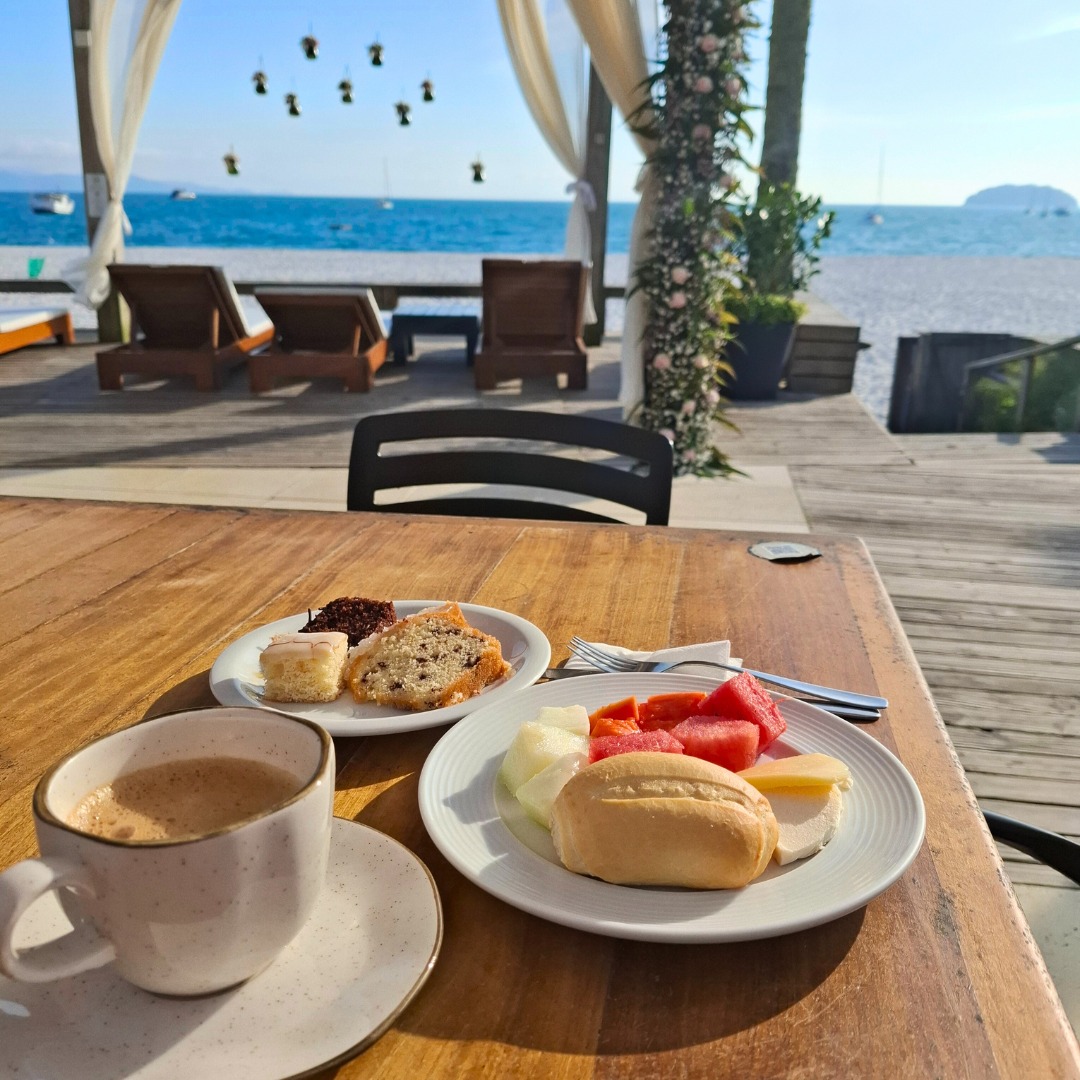 Café da manhã servido com o mar ao fundo, no Restaurante Alameda dos Sabores, em Florianópolis