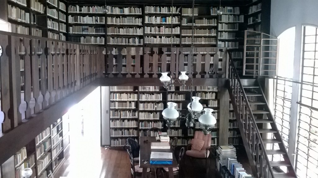 Vista de prateleiras e livros da Biblioteca Professor Osni Regis