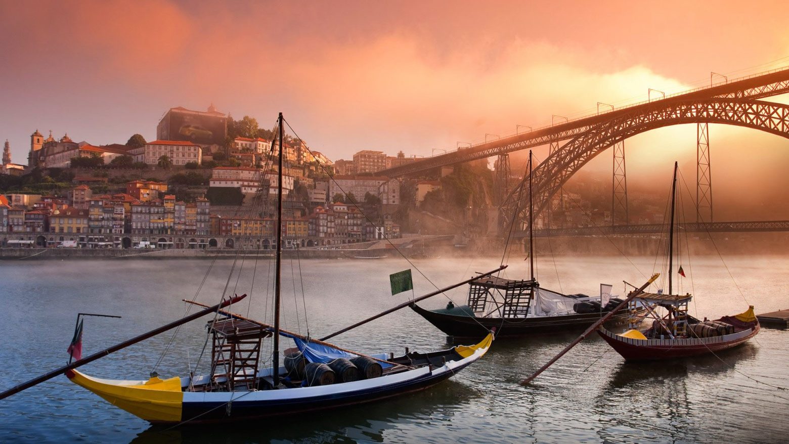 Barcos no Douro, névoa, casarões do Porto ao fundo. POnte D.Luís I.
