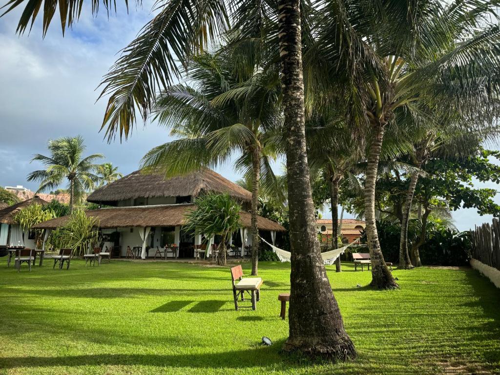 Pousada Duna Paraíso - Casa ao fundo com coqueiros na lateral e gramado extenso