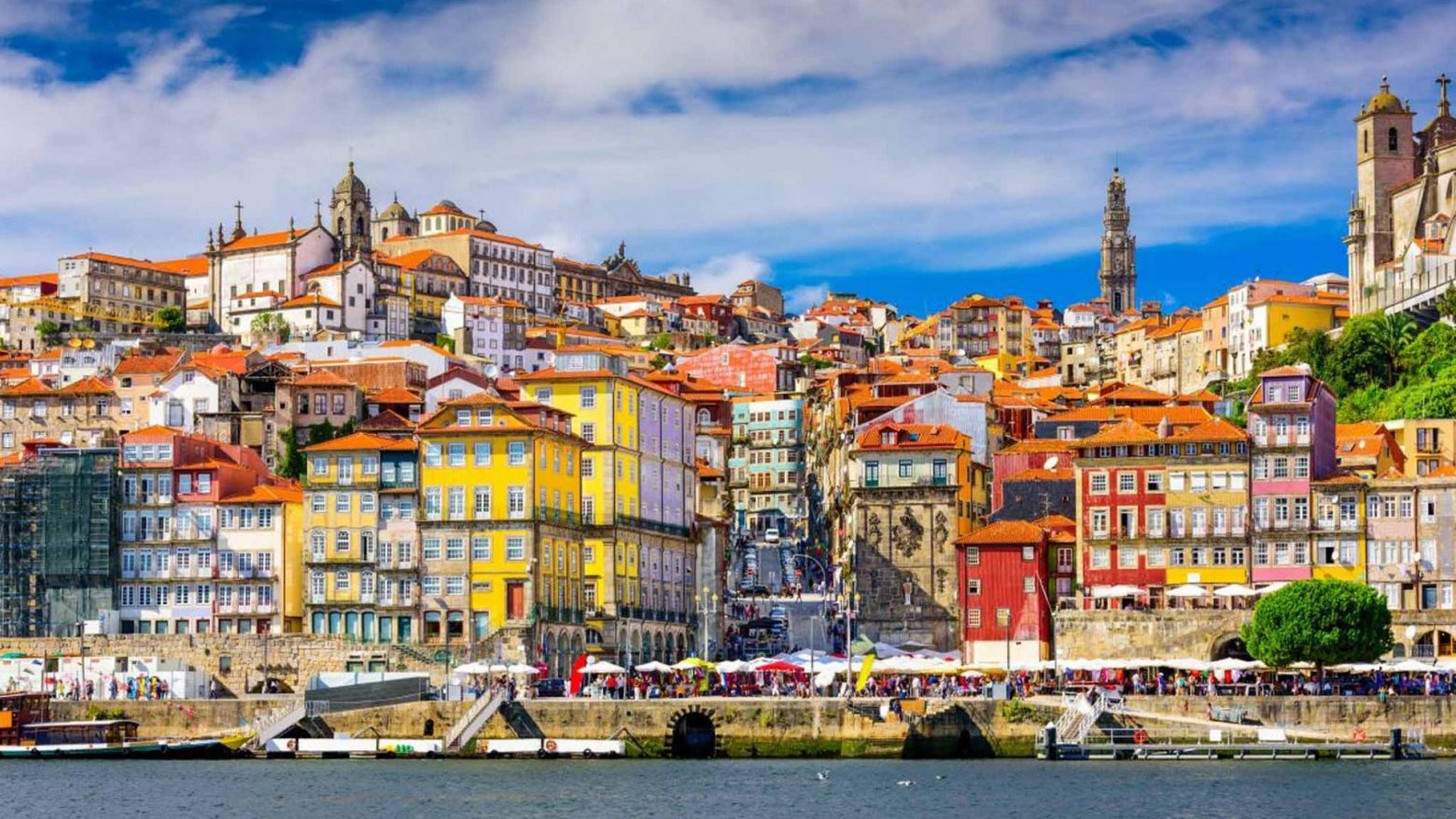 Casarões da Ribeira do Porto, feirinha e pessoas andando. Rio Douro.