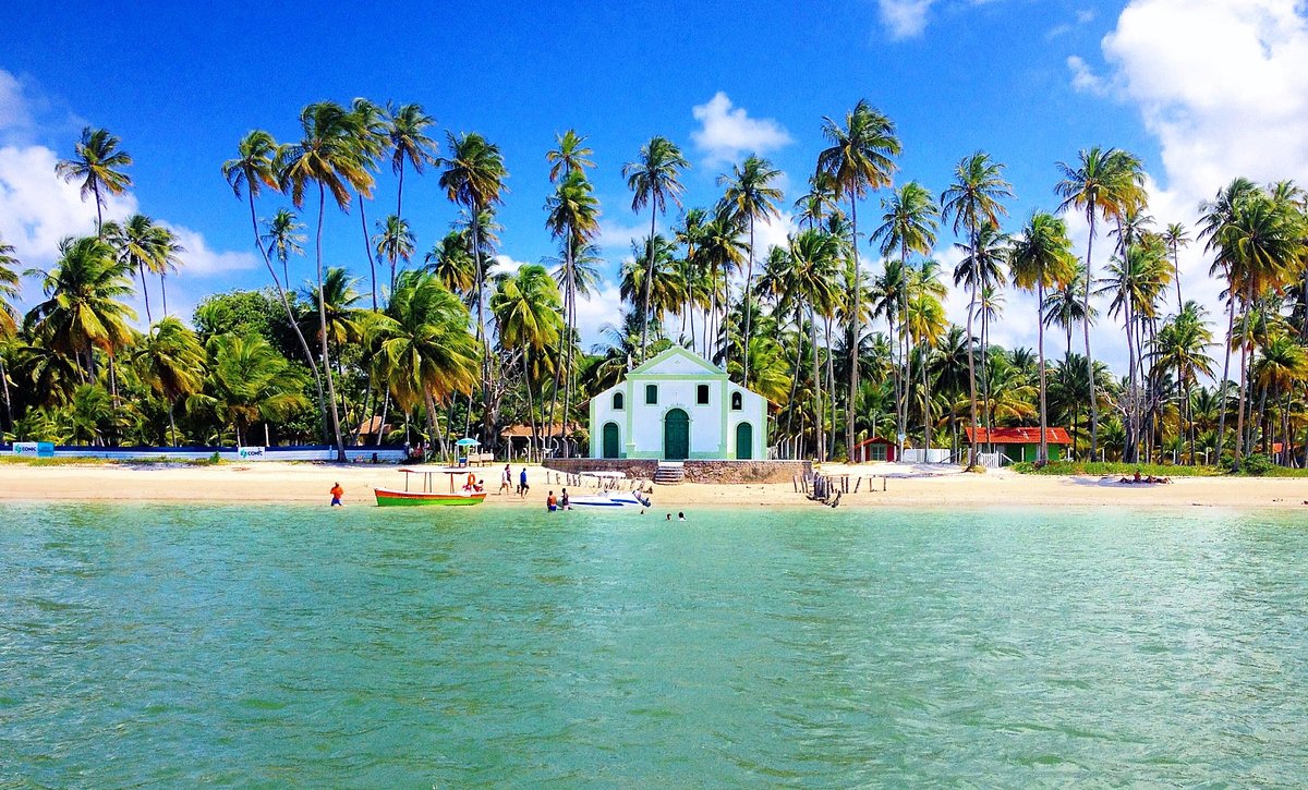 Praia dos Carneiros em Sergipe - Imagem com uma igreja ao fundo e o mar a frente, coqueiros nas laterais da igreja. 