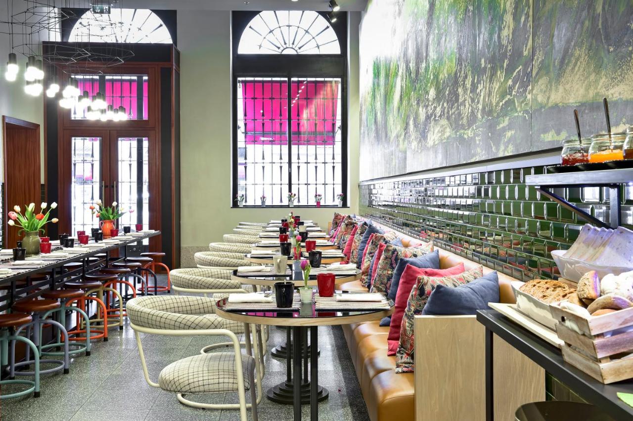 The Editory House Ribeira Porto Hotel - Restaurante, mesas postas, cadeiras, almofadas vermelhas, azuis e estampadas.