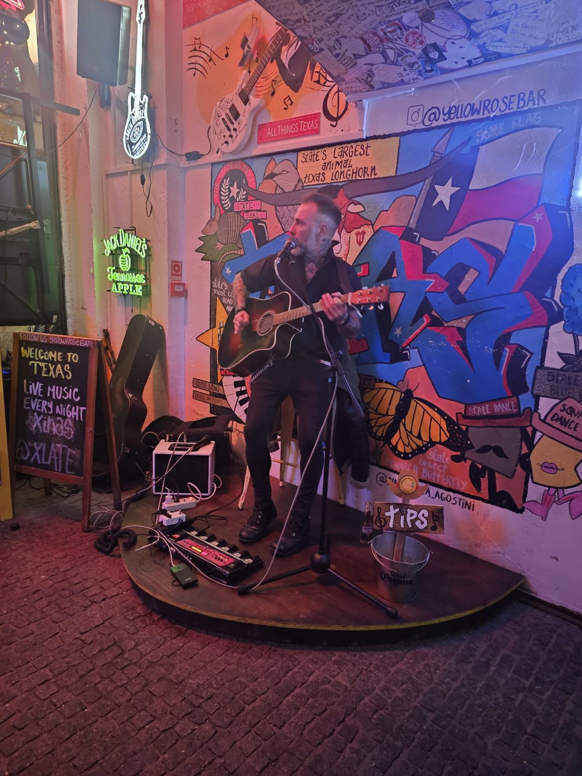 Homem tocando guitarra Yellow Rose Bar