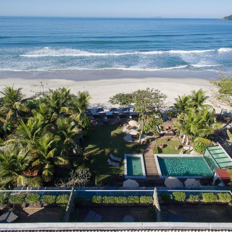 Vista do mar com piscinas a frente e árvores de coqueiros ao redor -Hotel Spa Nau Royal
