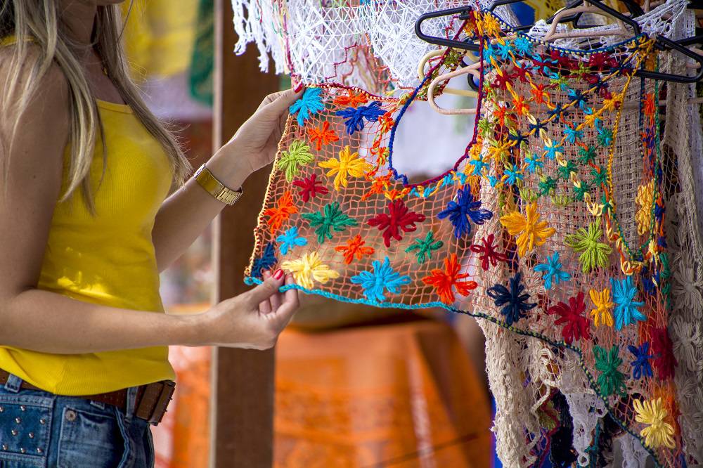 mulher vendo renda em feira de artesanato