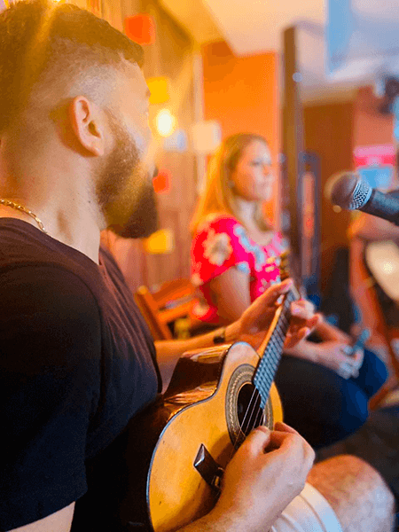 HOmem tocando violão e mulher cantando. Música ao vivo.