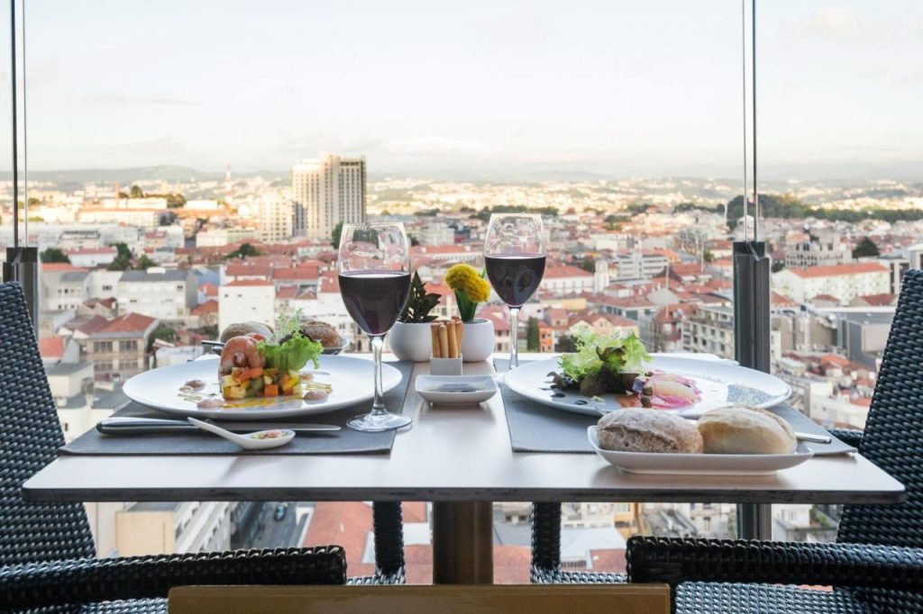 Mesa posta, taças de vinho, refeição, terraço com vista para o Porto.