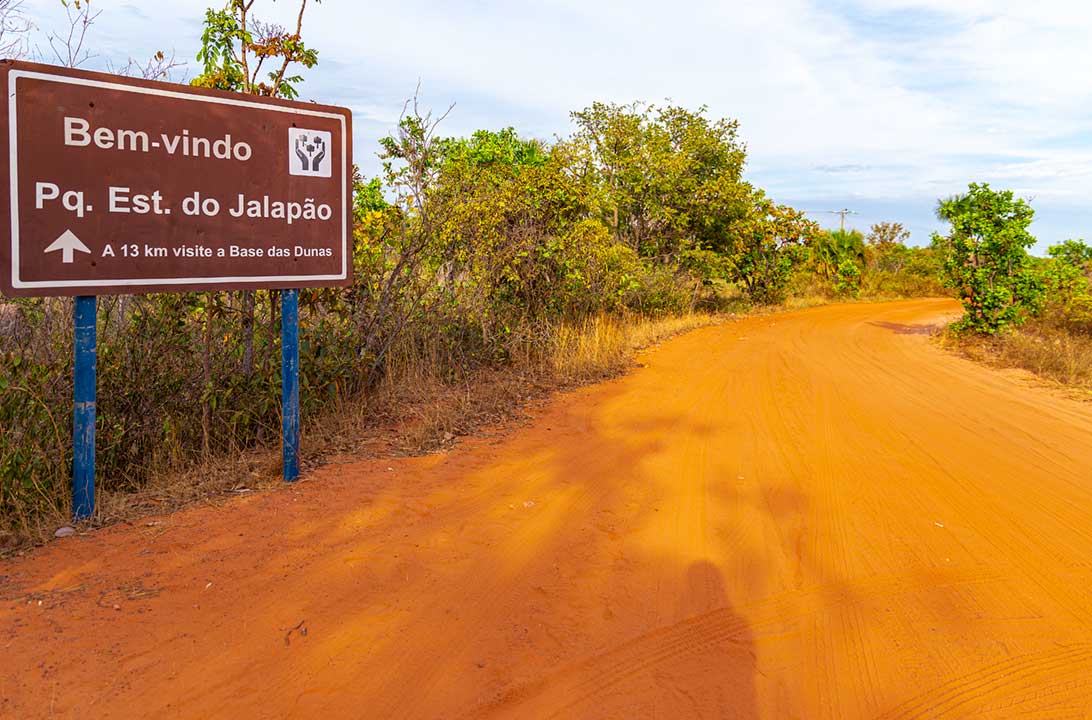 Estrada de terra com placa sinalizando a entrada ao Parque Estadual do Jalapão