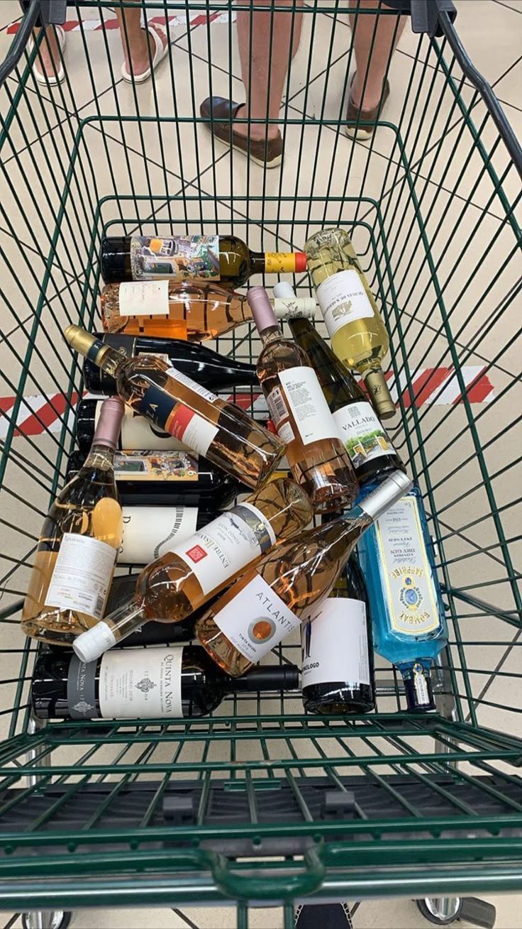 Uma foto de um carrinho de mercado cheio de vinhos. 